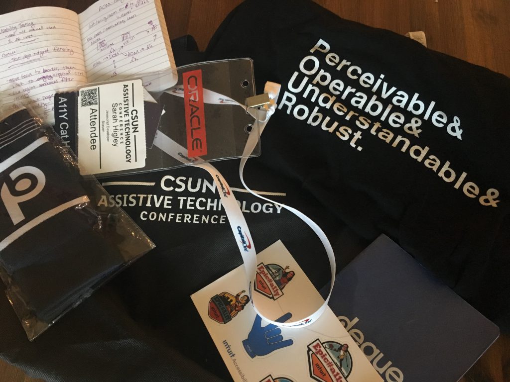 Photo of CSUN swag including a tshirt, name badge, stickers, socks, and notebook